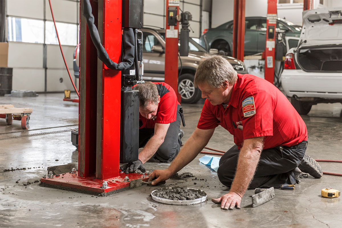 rack-l45x-install-hemannautomotive4.jpg service reps using cement to mount four post lift
