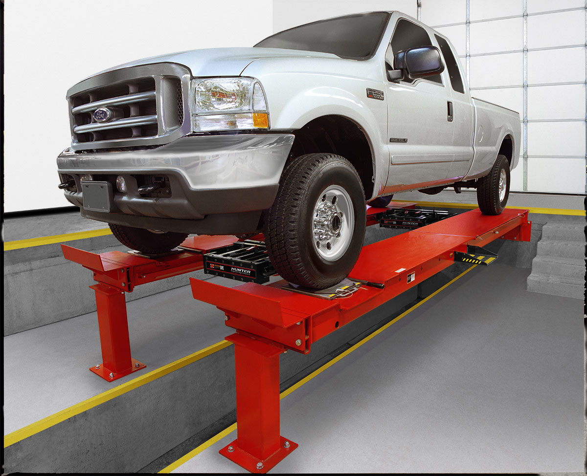 white truck on pit rack in shop